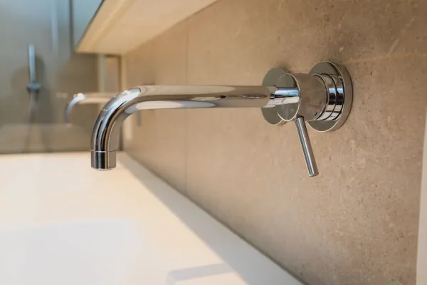 Inbouwkraan in chroom boven een witte lavabo, realisatie van ID Interieur