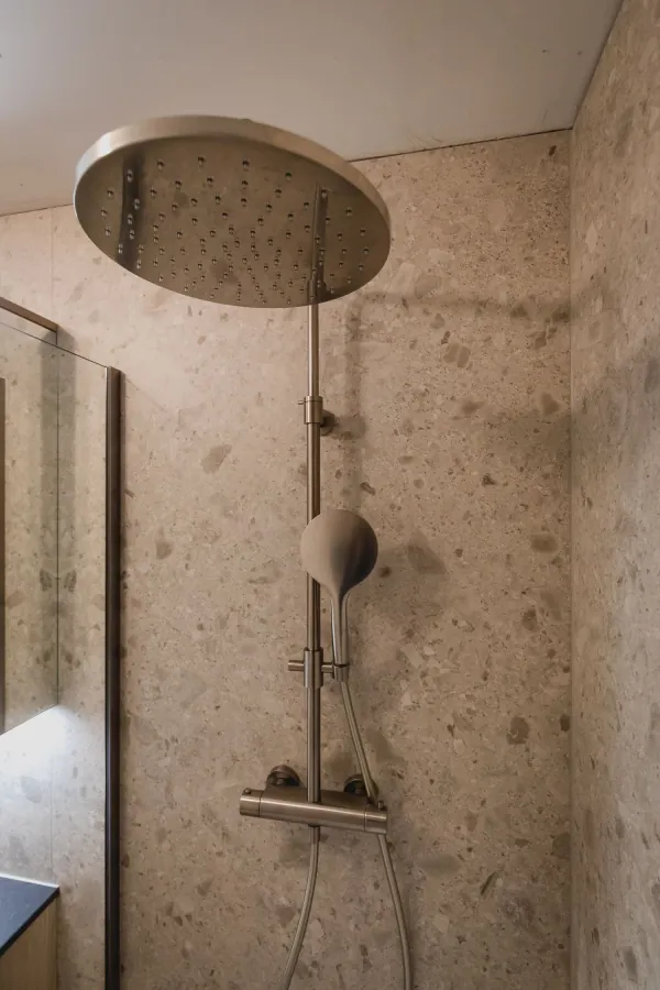 Regendouche met thermostaatkraan en wanden in terrazzo, realisatie van ID Interieur