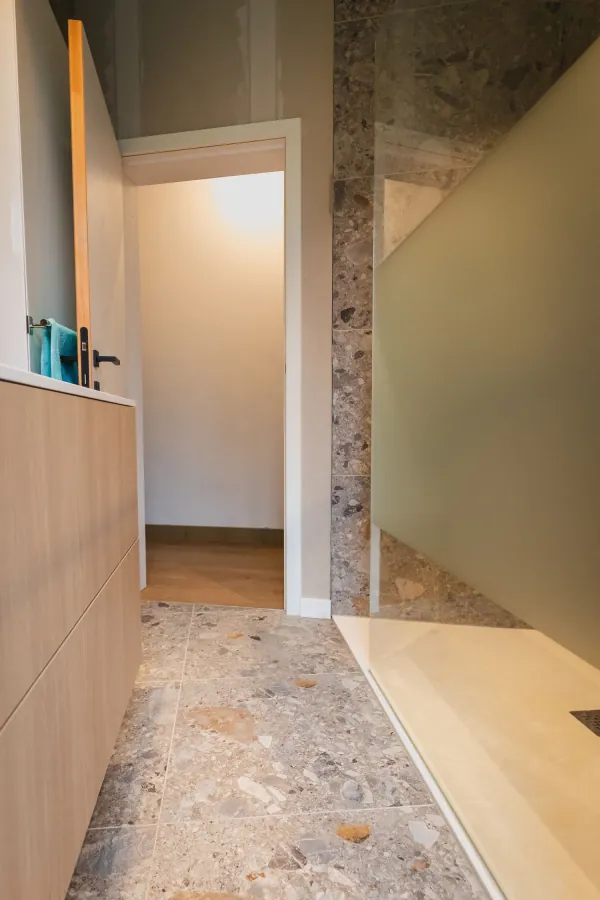 Badkamer met houten kastwand en matglazen douchewand, realisatie van ID Interieur
