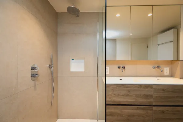 Inloopdouche met glazen wand en houten badmeubel met spiegelwand, realisatie van ID Interieur