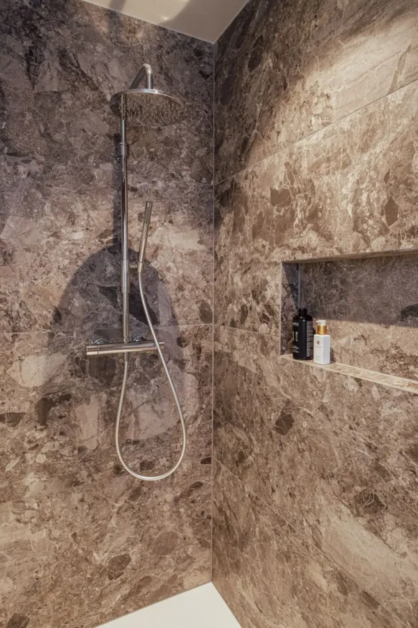 Douche in bruine natuursteenlook met ingewerkte nis, realisatie van ID Interieur
