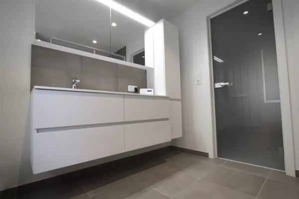 Zwevend wit badmeubel met verlichte spiegelkast en glazen deur, realisatie van ID Interieur