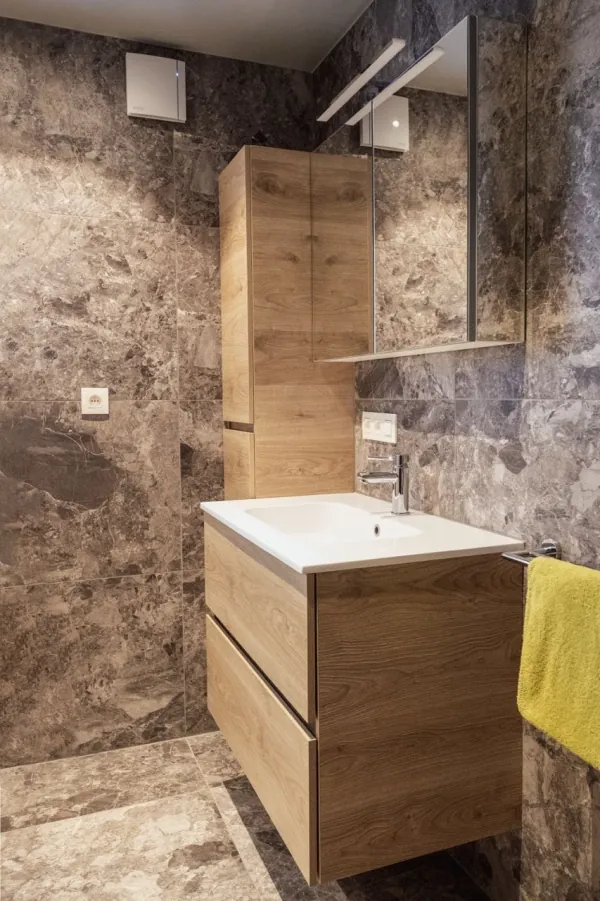 Badmeubel in eik tegen wanden in natuursteenlook, realisatie van ID Interieur