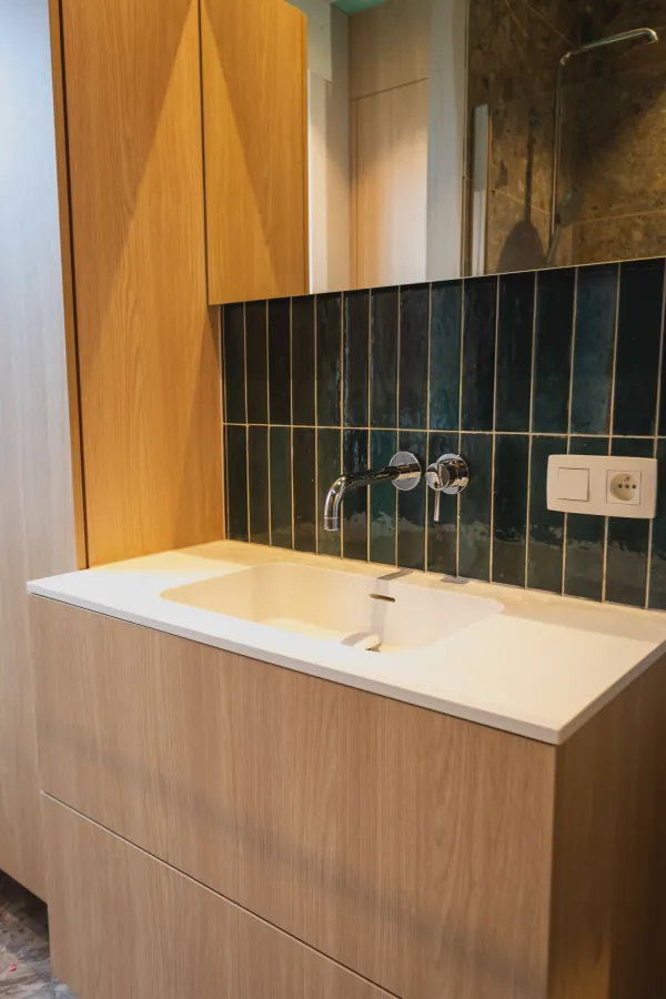 Badmeubel in eik met groene tegels als spatwand, realisatie van ID Interieur