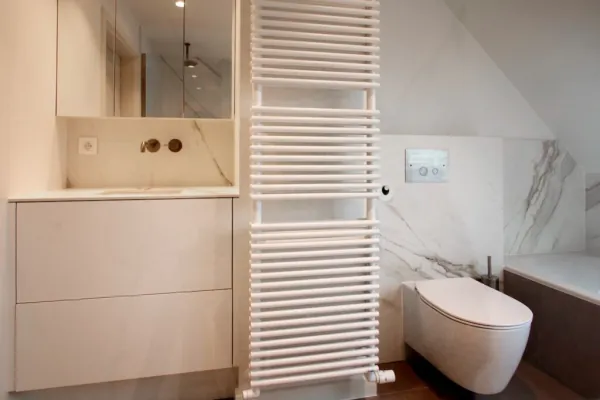 Wit badmeubel met handdoekradiator en hangend toilet, realisatie van ID Interieur