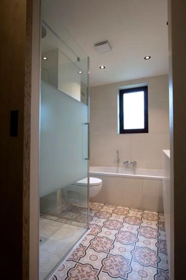 Badkamer met matglazen deur en vloer in cementtegels, realisatie van ID Interieur