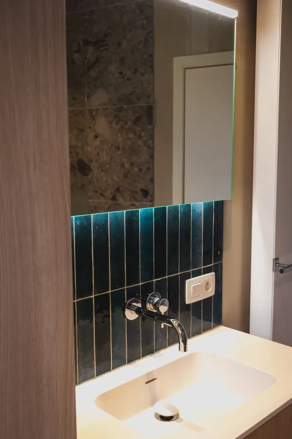 Lavabo met groene tegels en zwarte inbouwkraan, realisatie van ID Interieur