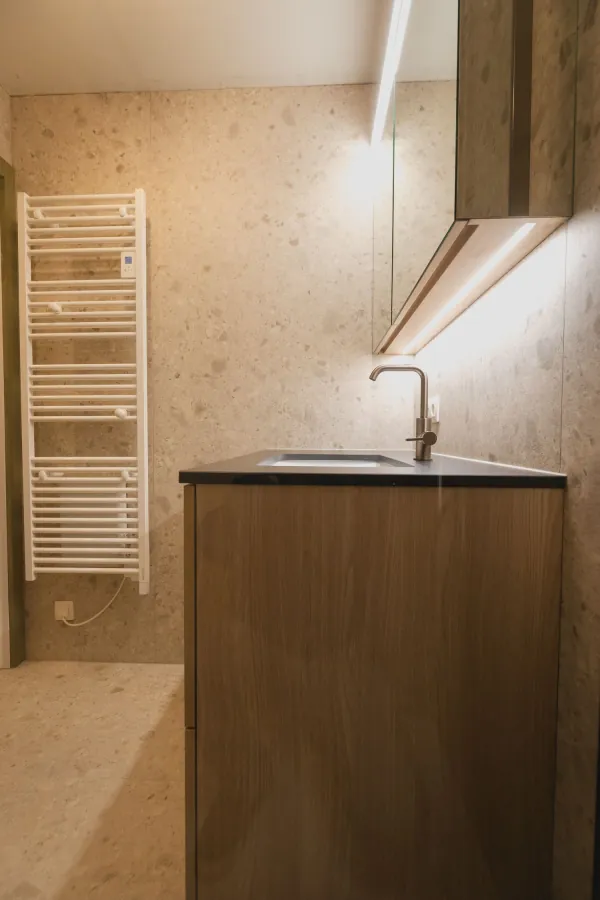 Badmeubel in donker hout met handdoekradiator, realisatie van ID Interieur