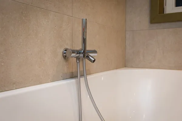 Bad met chromen badkraan en wandtegels in zandkleur, realisatie van ID Interieur
