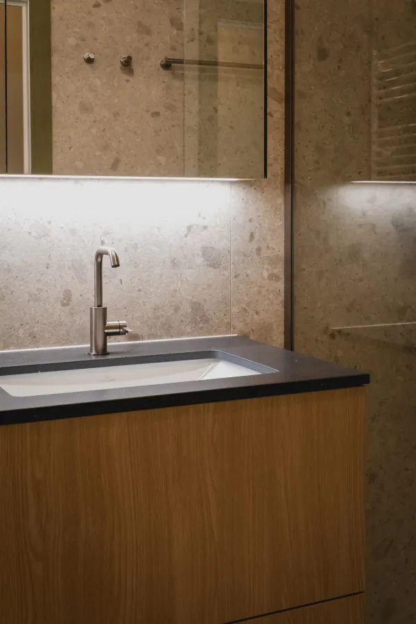 Lavabo met donker blad en houten onderkast, realisatie van ID Interieur