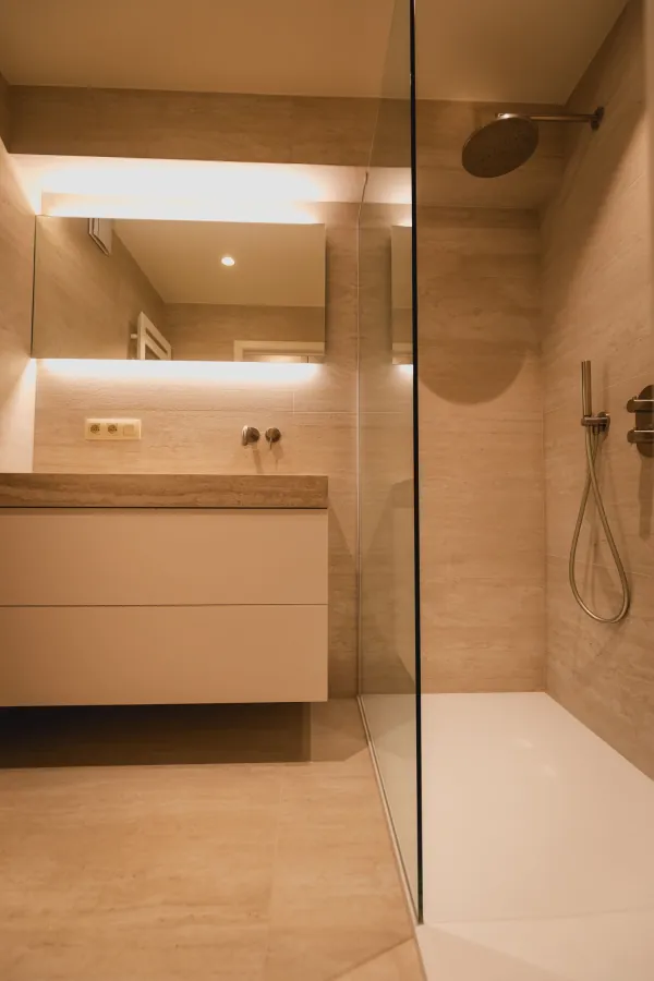 Inloopdouche met glazen wand en wit badmeubel met verlichte spiegel, realisatie van ID Interieur