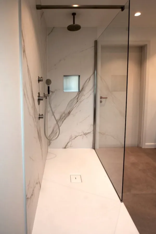 Inloopdouche met marmerlook wanden en zwarte douchestang, realisatie van ID Interieur