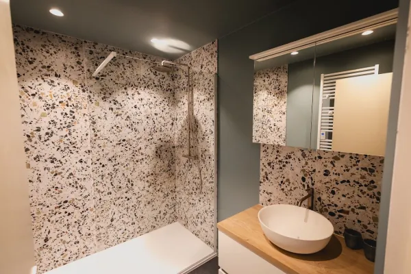 Badkamer met terrazzo wand, waskom en spiegelkast met verlichting, realisatie van ID Interieur