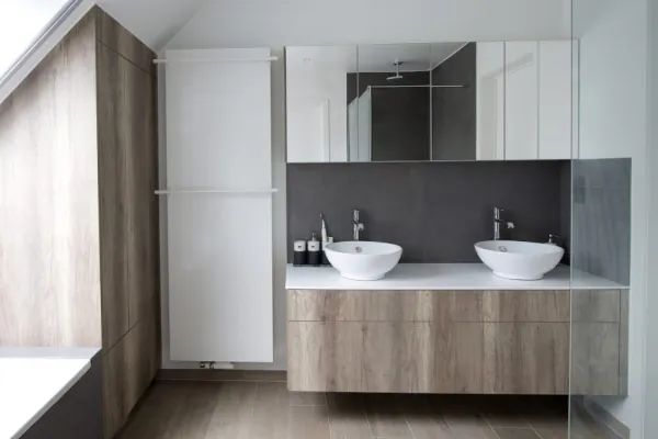 Badkamer met twee waskommen op houten badmeubel en hoge kasten, realisatie van ID Interieur