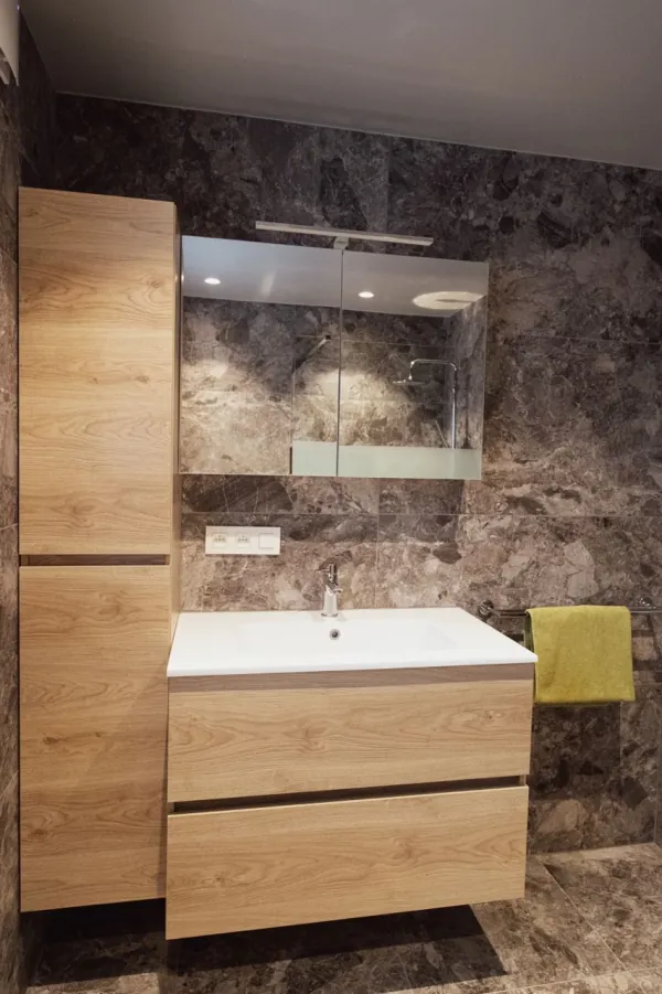 Badmeubel en kolomkast in eik tegen bruine natuursteenlook, realisatie van ID Interieur