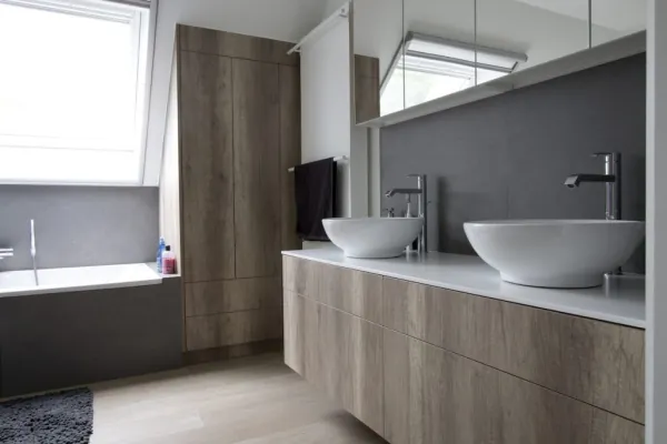 Badkamer met twee opzetwaskommen en houten hoge kast, realisatie van ID Interieur