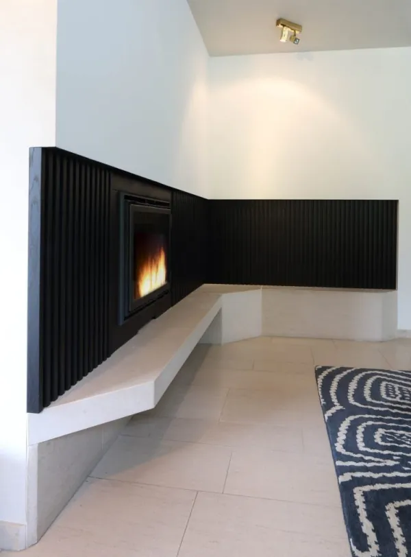 Gashaard in een zwart lamellenmeubel met witte zitbank, realisatie van ID Interieur