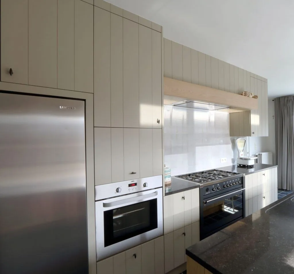 Keuken met lichte kasten, inox koelkast en fornuis, Interieurarchitect Sint-Andries door ID Interieur