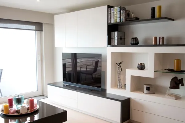 Wit tv-meubel met open nissen in een speels patroon, realisatie van ID Interieur