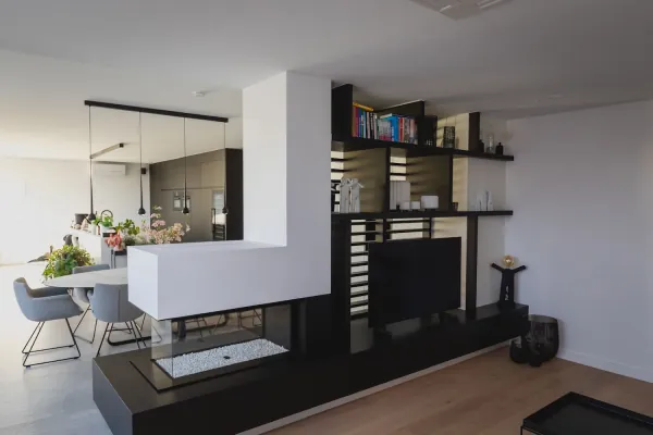Leefruimte met wandmeubel, open kast en doorkijkhaard, realisatie van ID Interieur