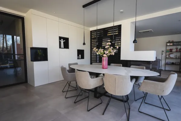 Eetruimte met witte kastenwand, nissen en lamellenwand, realisatie van ID Interieur