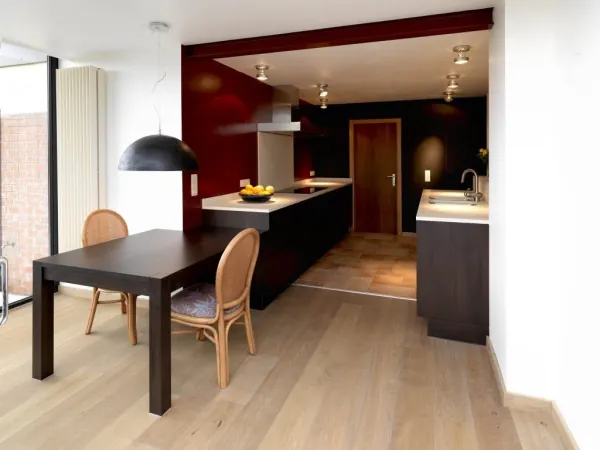 Leefkeuken met rode accentwand, eettafel en eiland, realisatie van ID Interieur