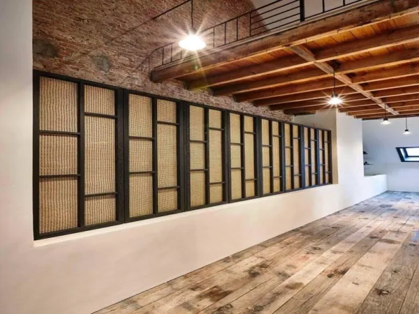 Ruimte met houten balken, bakstenen muur en kastenwand, realisatie van ID Interieur
