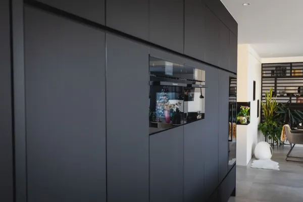 Zwarte kastenwand met inbouwoven, realisatie van ID Interieur