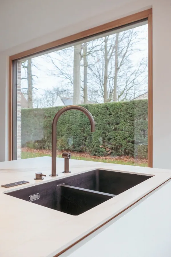 Spoelbak met bronzen kraan voor een groot raam, realisatie van ID Interieur