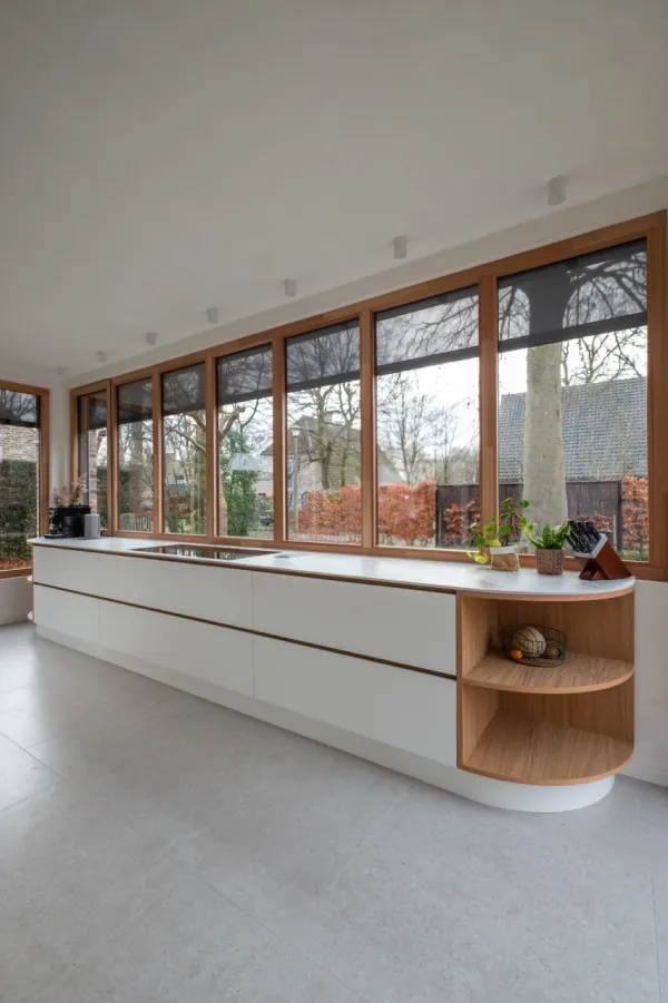 Witte keuken met afgeronde eiken open kast en grote ramen, realisatie van ID Interieur