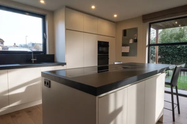 Keuken met zwart werkblad, eiland en hoge kasten, realisatie van ID Interieur