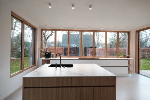 Keuken met eiken kookeiland en lange raampartij, realisatie van ID Interieur