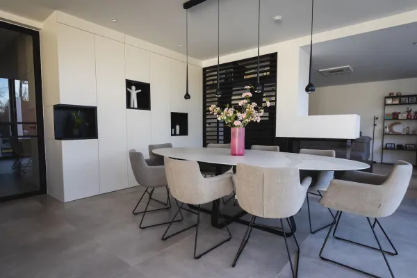 Eetruimte met witte kastenwand, nissen en eettafel, realisatie van ID Interieur