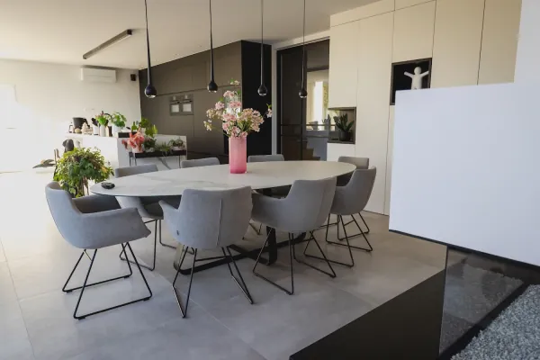 Eetruimte met witte kastenwand naast een glazen gashaard, realisatie van ID Interieur