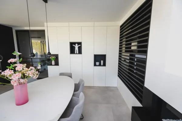 Witte kastenwand met nissen naast een zwarte lamellenwand, realisatie van ID Interieur
