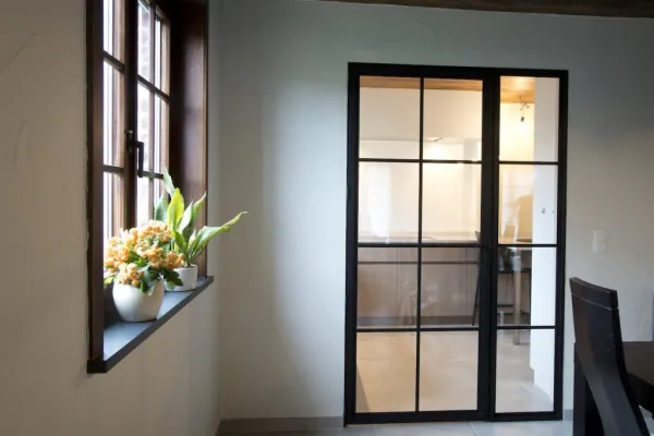 Stalen binnendeur met glas in een lichte gang, realisatie van ID Interieur