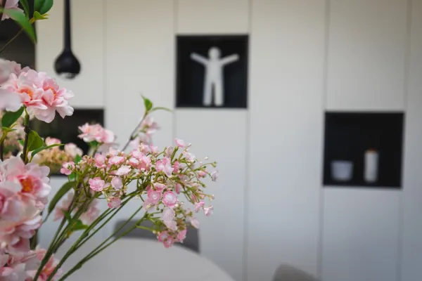 Witte kastenwand met zwarte nis, detail met bloemen, realisatie van ID Interieur