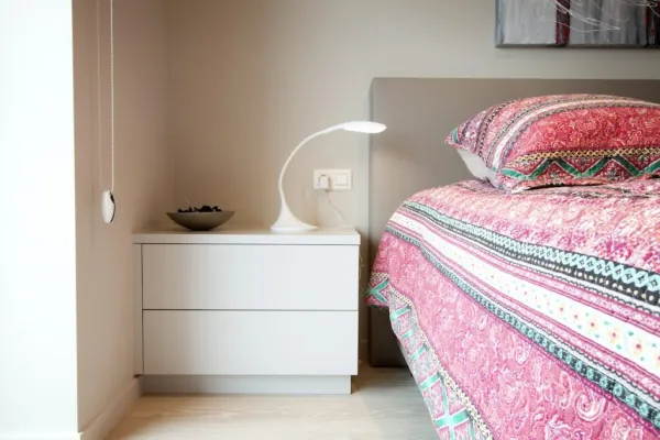 Witte nachtkastjes op maat naast een bed, realisatie van ID Interieur