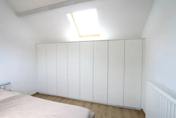 Witte kasten op maat onder een schuin dak, realisatie van ID Interieur