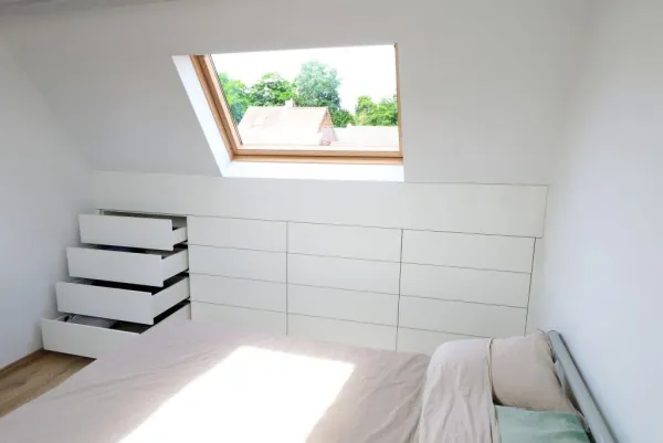 Ladekasten op maat onder het schuine dak van een slaapkamer, realisatie van ID Interieur