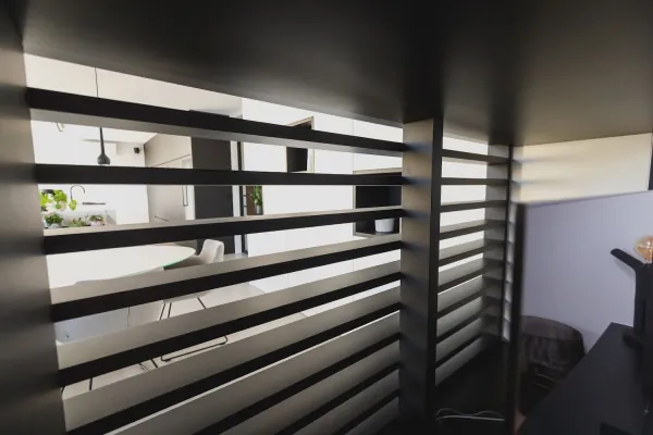 Zwarte lamellenwand als ruimteverdeler, realisatie van ID Interieur