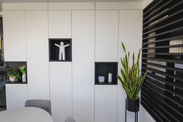 Witte kastenwand met zwarte nissen en lamellenwand, realisatie van ID Interieur