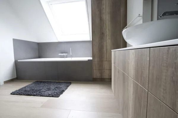 Badkamer met ingebouwd bad en kasten in houtlook, realisatie van ID Interieur